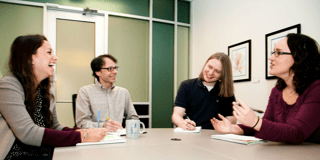 four people in a work meeting