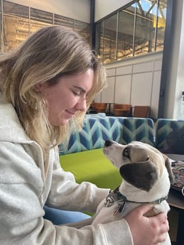 Woman looking down at dog and smiling